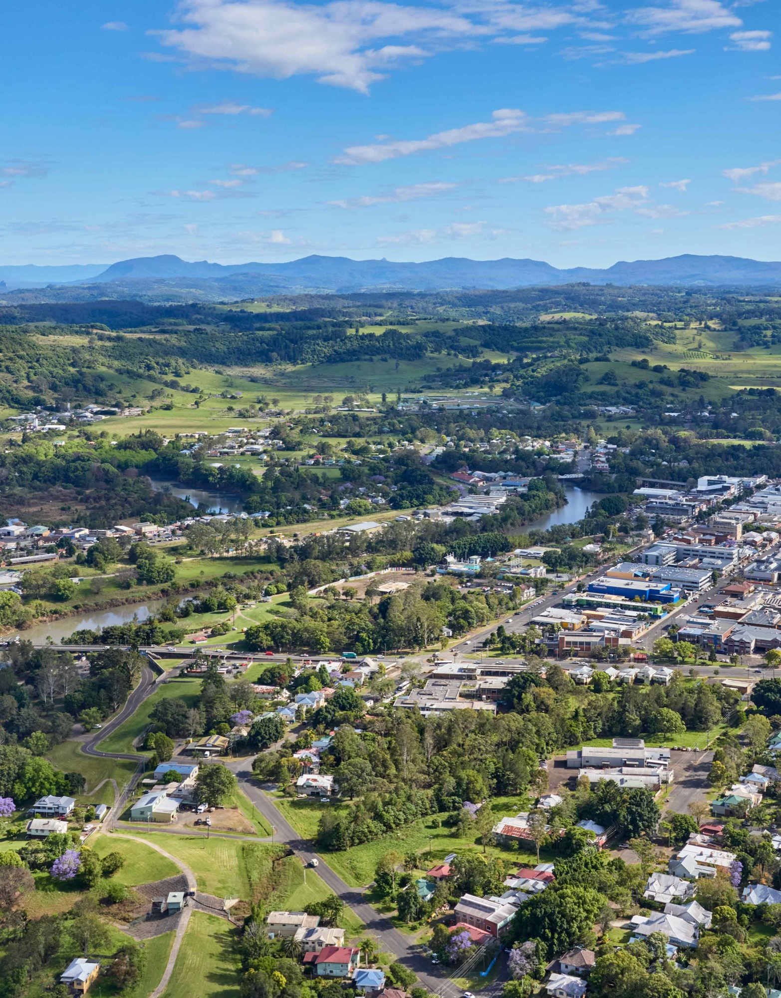 Aerial view over a Northern Rivers town, river and hinterland ranges